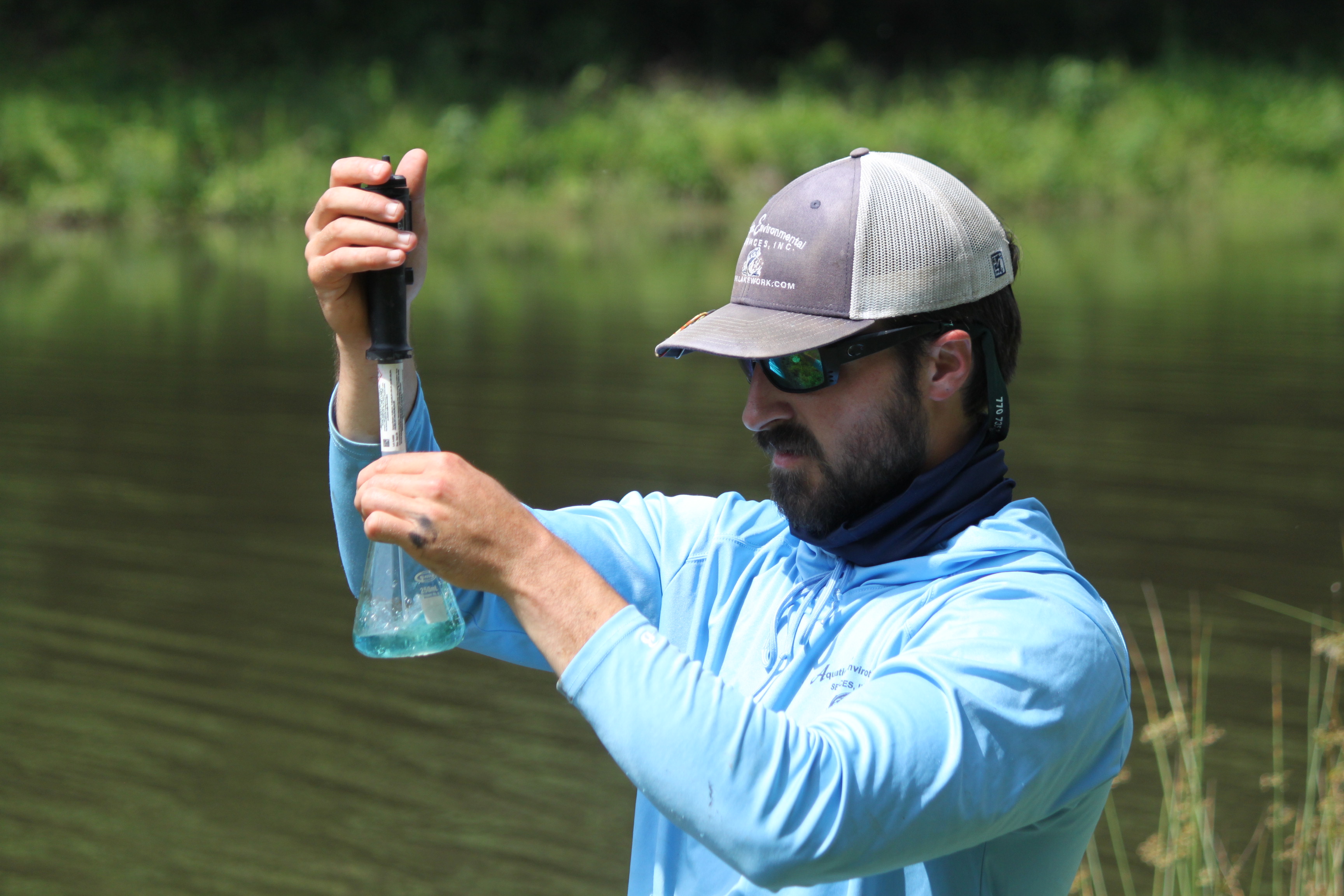 A technician conducts water testing in a vial